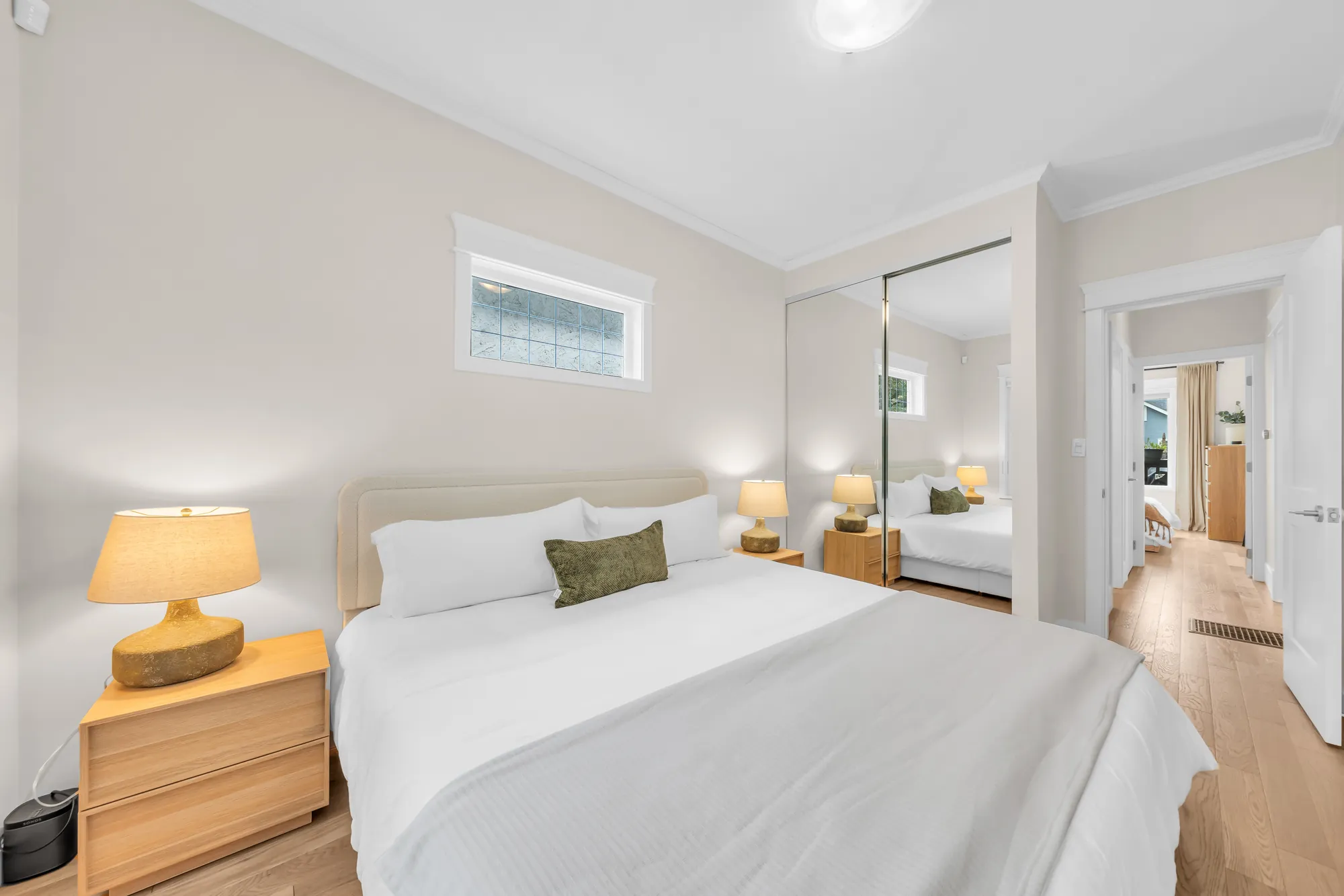 The back bedroom toward its mirrored closet and the door to the hall